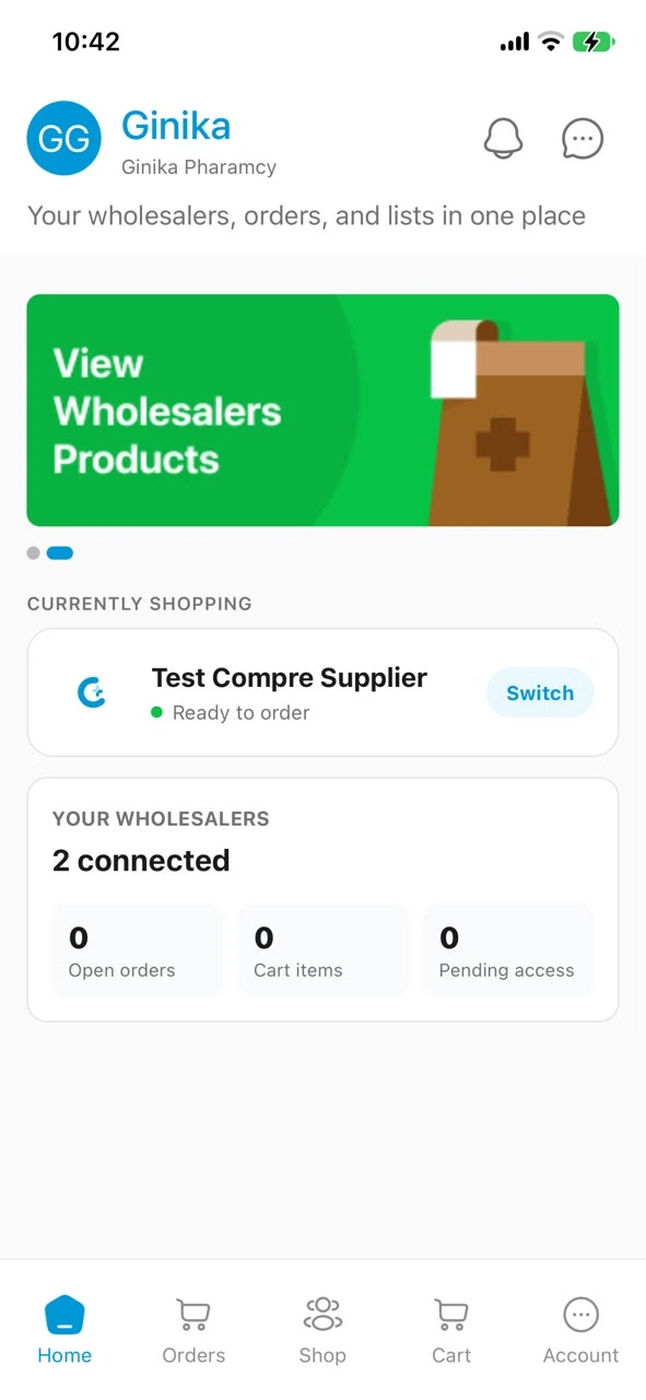 The Compre app home screen for Ginika Pharamcy, showing Test Compre Supplier as the shop currently being shopped and the wholesalers connected